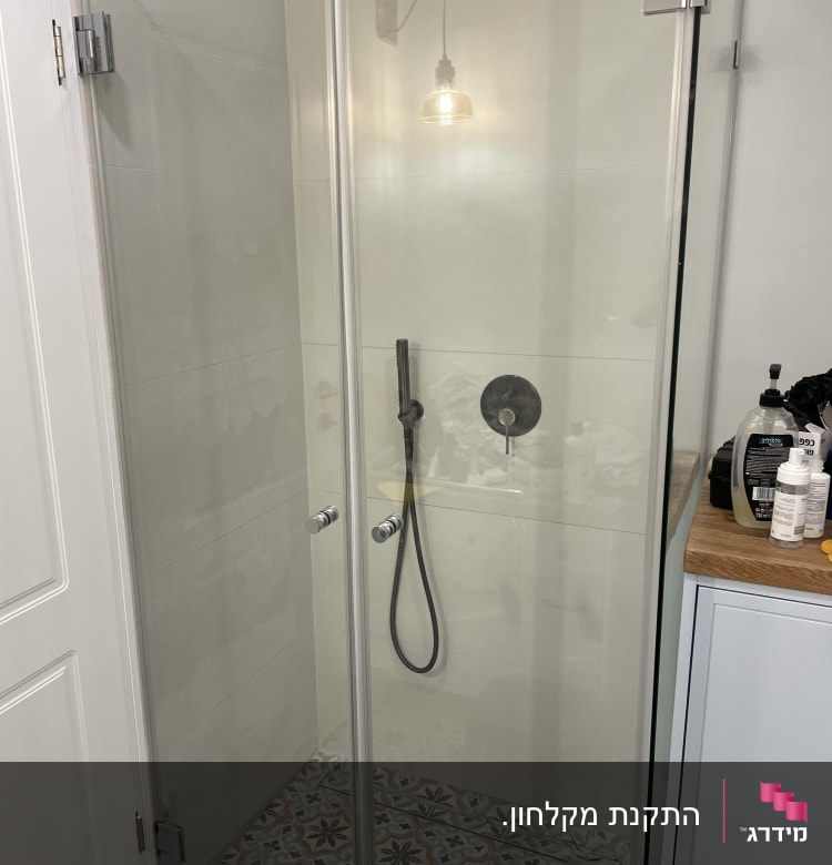 מקלחון זכוכית עם ראש מקלחת וכפתורי שליטה